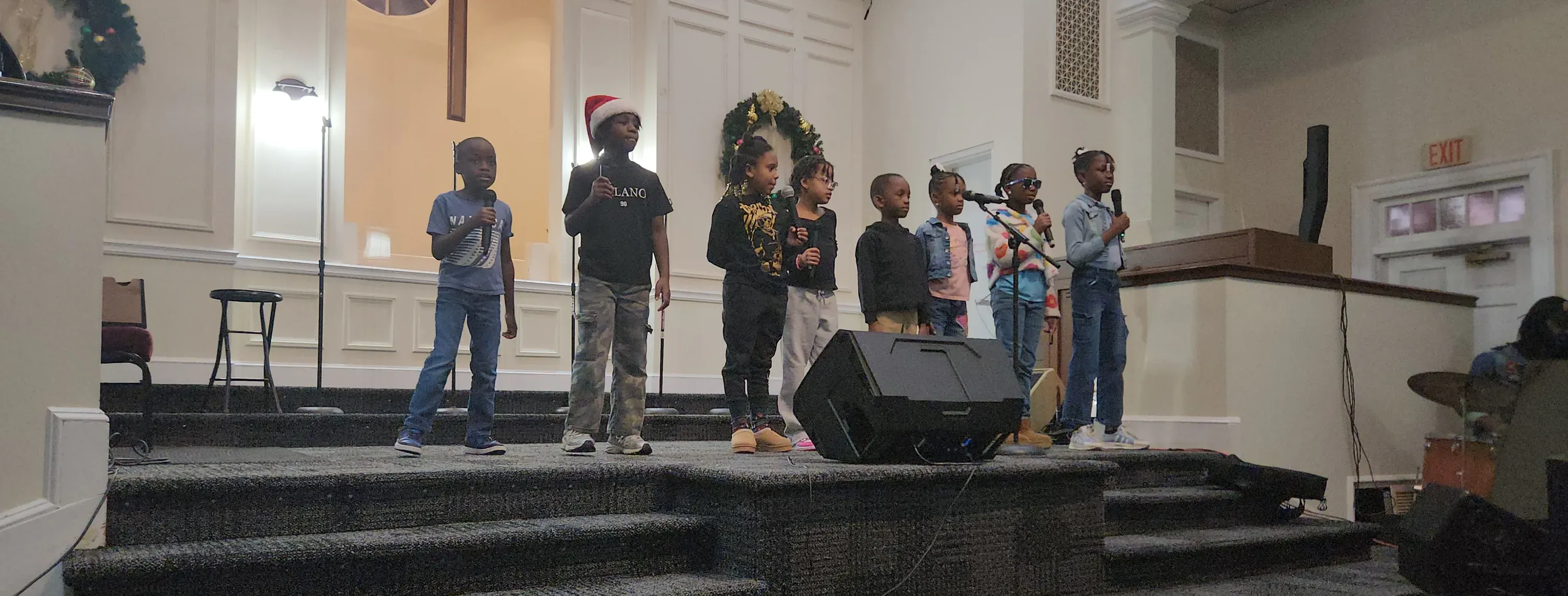 Children singing at the microphones on the platform during a service