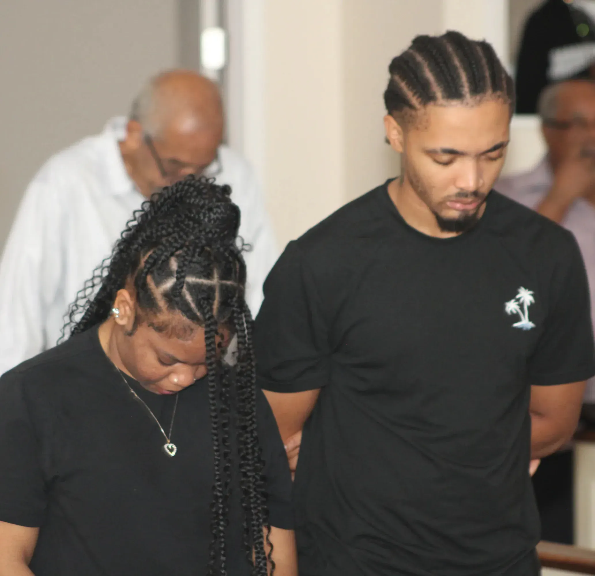 Two members standing in prayer during a service