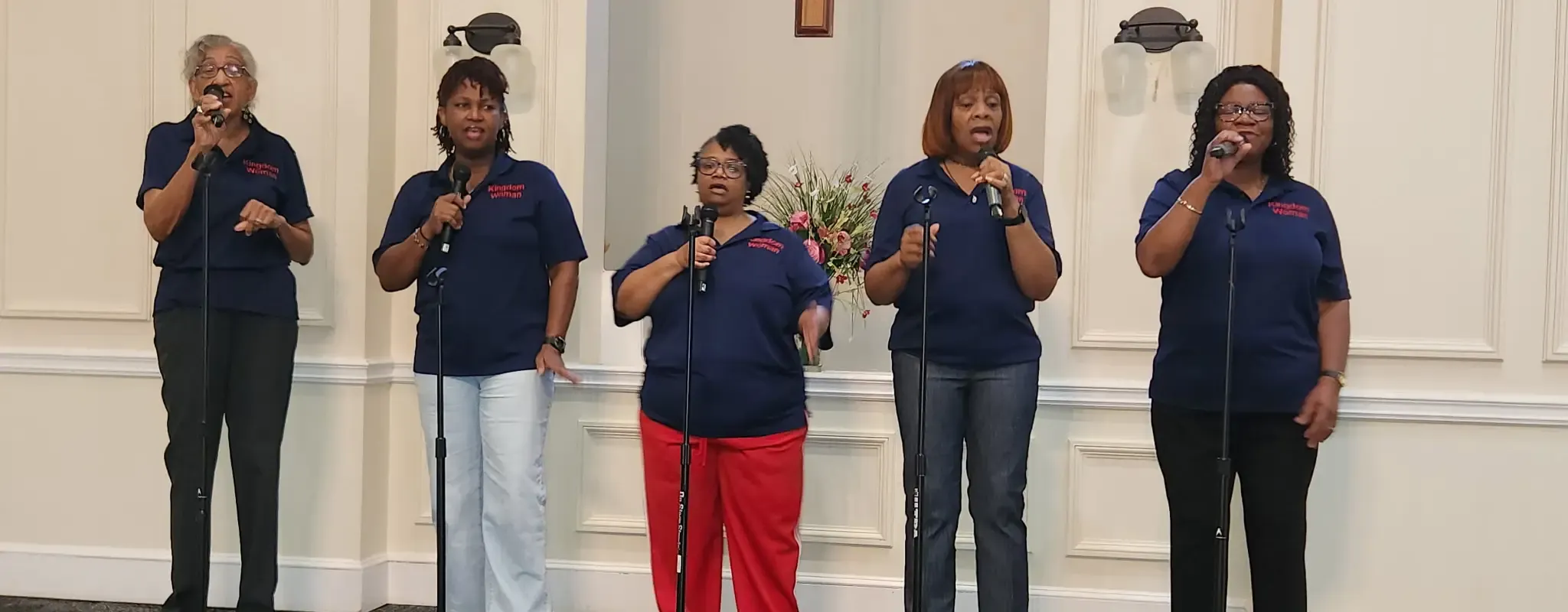 The women's praise team singing at the microphones during a service